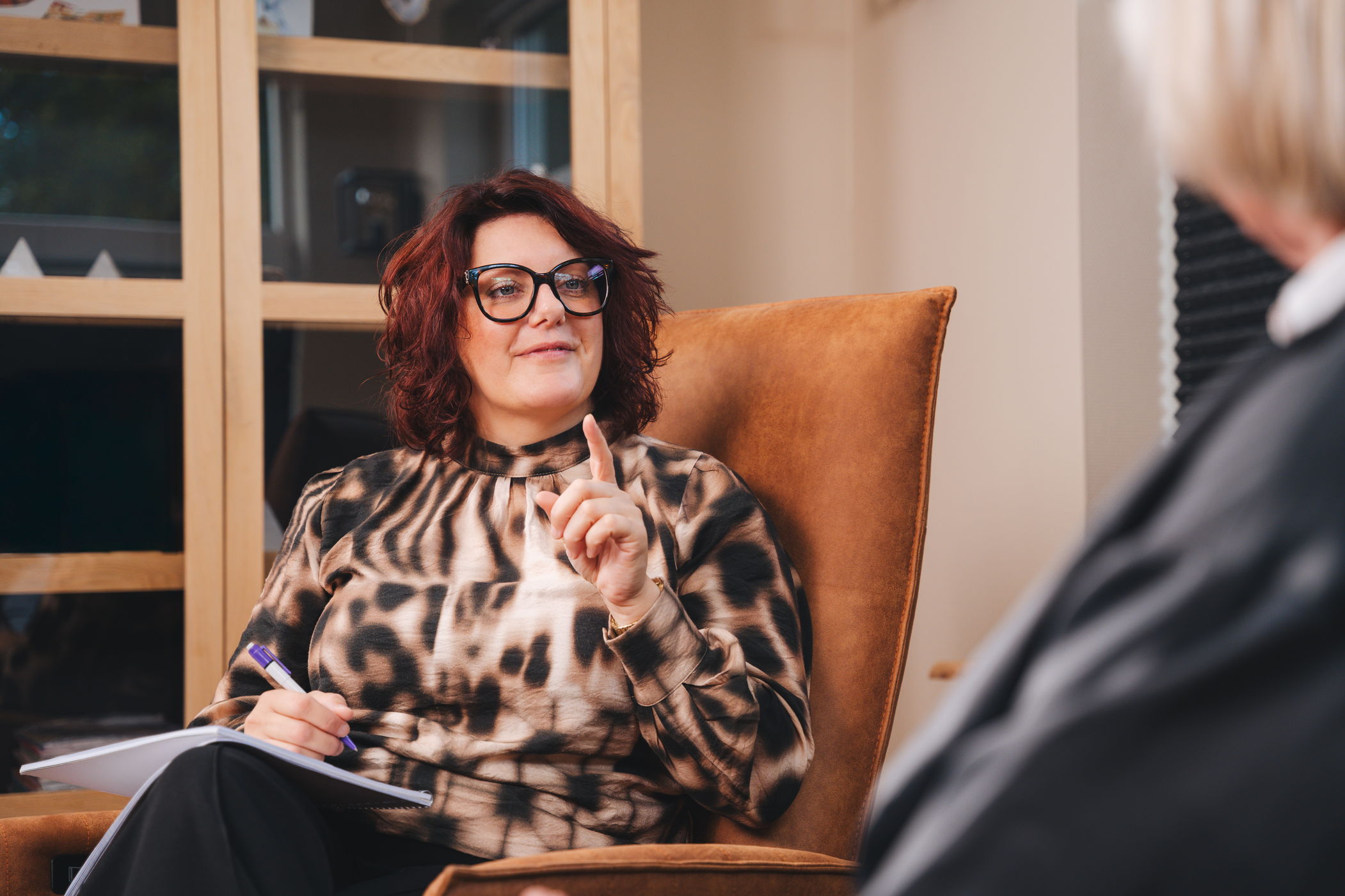 Marjolein zit in de stoel en praat met haar wijsvinger - Migraine Specialist